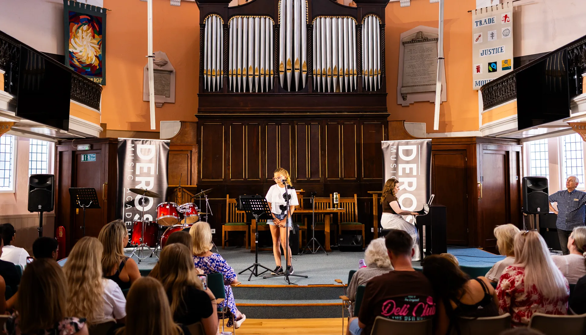 A young performer on stage at a DeRosa Music Academy student showcase