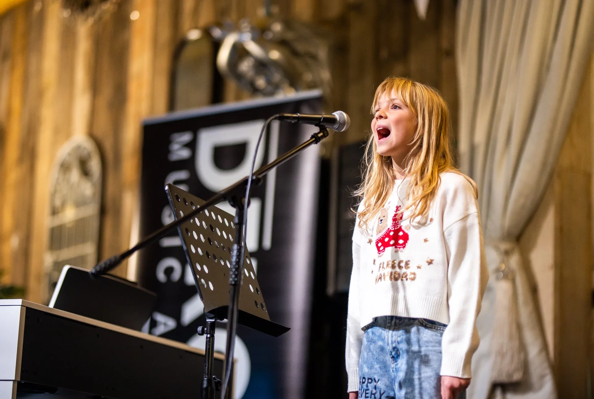 A young singer performs at a DeRosa Music Academy showcase